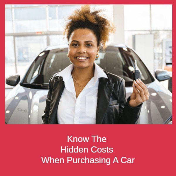 Lady at a car dealership with car keys standing infront of a vehicle. Know The Hidden Costs When Purchasing A Car